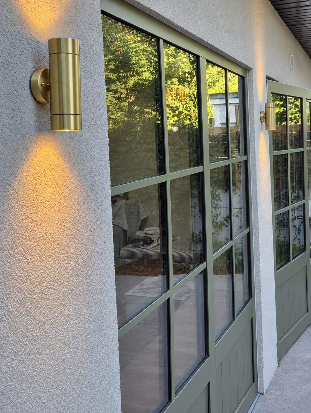 Brass up-and-down exterior wall lights beside glazed garden doors
