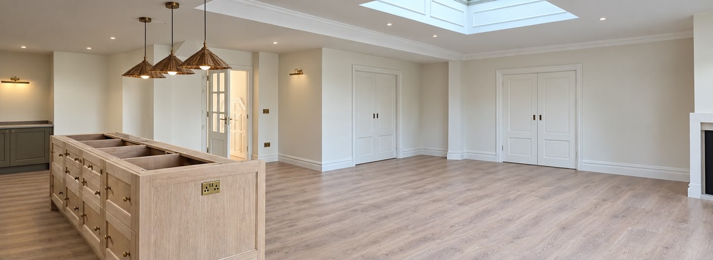 Pendant lights, recessed downlights and wall lights in an open-plan room with a brass island socket